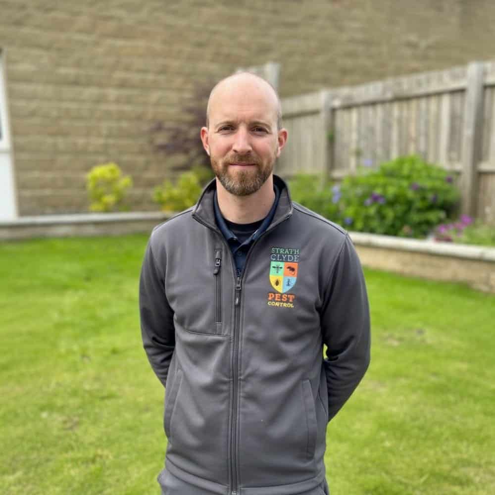 Local pest control technician outside a residential property